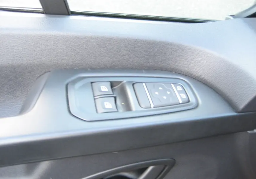 Panneau de commandes des vitres électriques côté conducteur du Renault Trafic Fourgon gris Comète 2025.