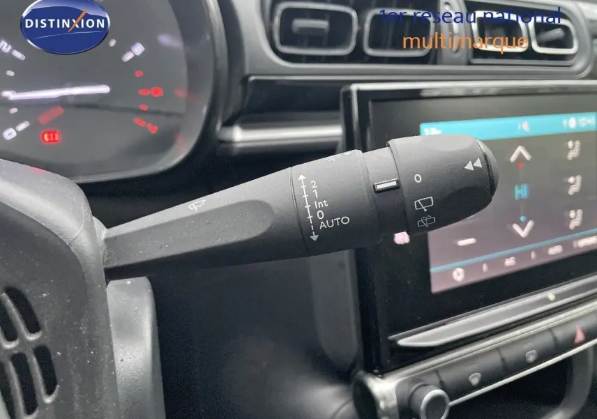 Gros plan sur la commande d'essuie-glace à gauche du volant dans l'habitacle d'une Citroën C3 gris acier toit noir 2023.