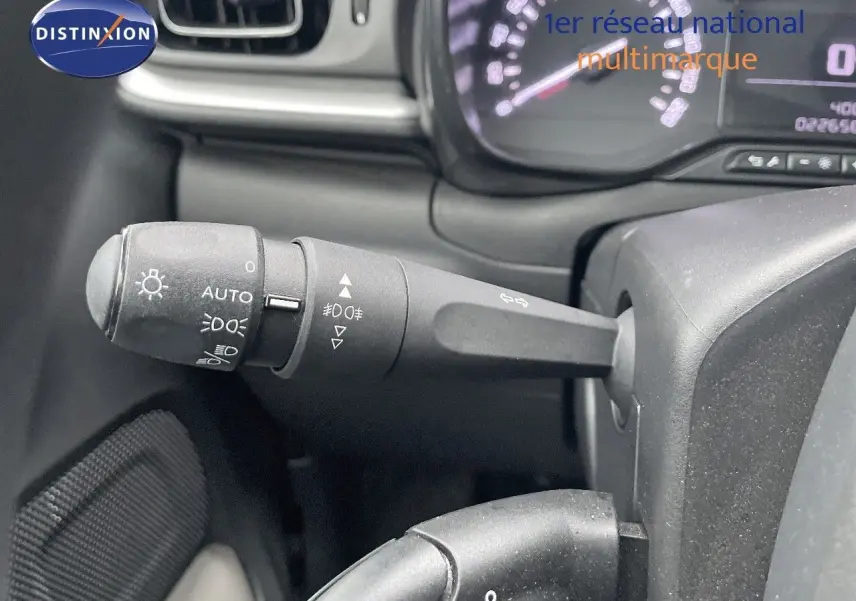 Gros plan sur la manette des feux et clignotants du tableau de bord d'une Citroën C3 gris acier toit noir 2023.