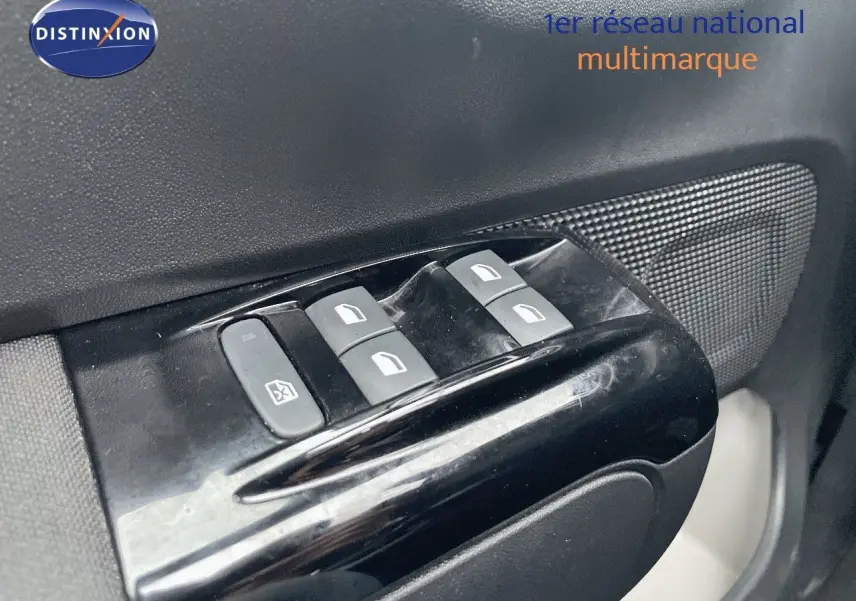 Gros plan sur les commandes des vitres électriques côté conducteur d'une Citroën C3 gris acier avec toit noir.