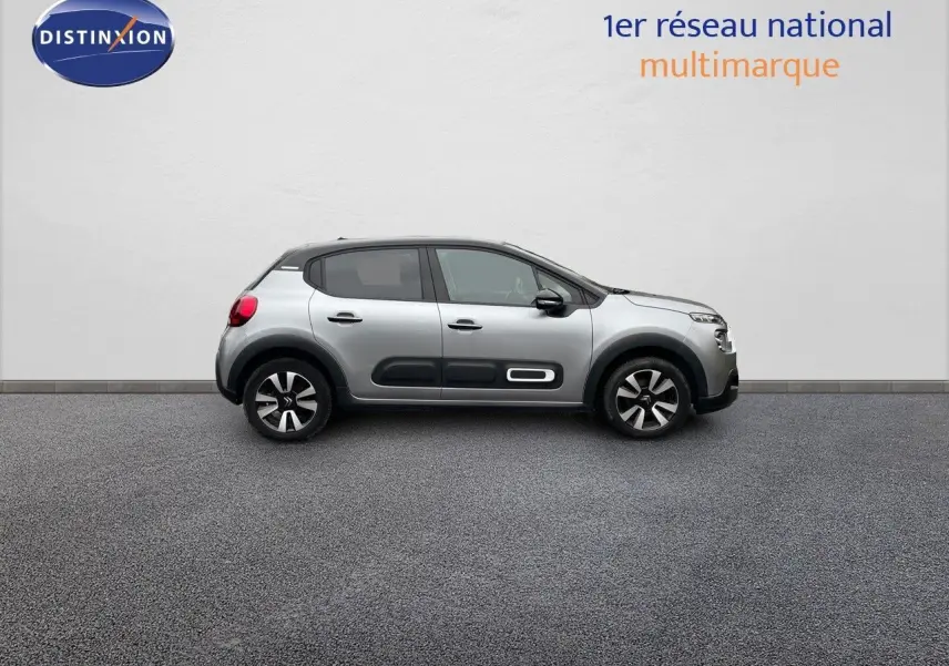 Profil droit d'une Citroën C3 2023 gris acier avec toit noir et protections latérales noires distinctives.