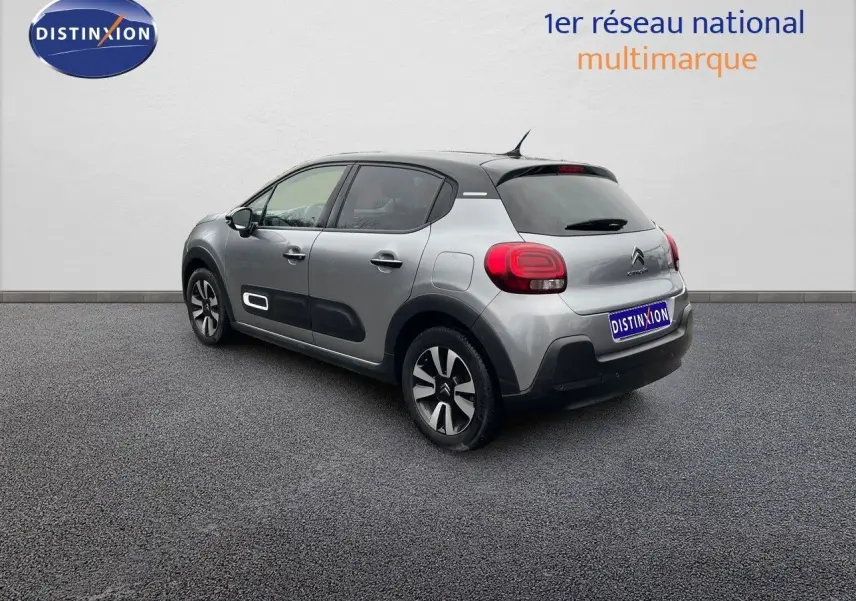 Citroën C3 2023 gris acier métal avec toit noir vue 3/4 arrière côté gauche, jantes bi-ton et protections latérales noires.