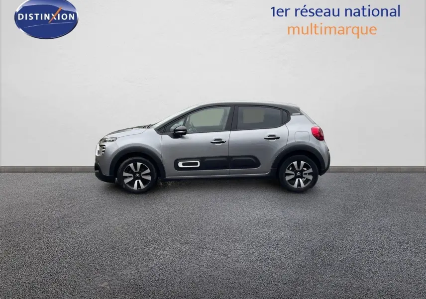 Profil latéral droit d'une Citroën C3 2023 gris acier métal avec toit noir et protections de porte noires.