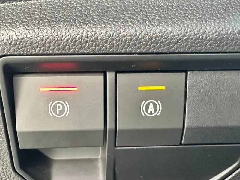 Gros plan sur les boutons de frein de stationnement et arrêt/redémarrage auto du moteur du Renault Espace gris Schiste 2024.