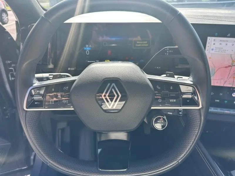 Vue rapprochée du volant cuir multifonction du Renault Espace 2024 avec écran numérique et GPS tactile visible.