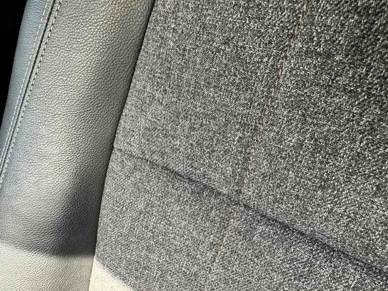 Gros plan sur la sellerie mixte tissu gris et similicuir gris schiste du siège avant Renault Espace 2024.