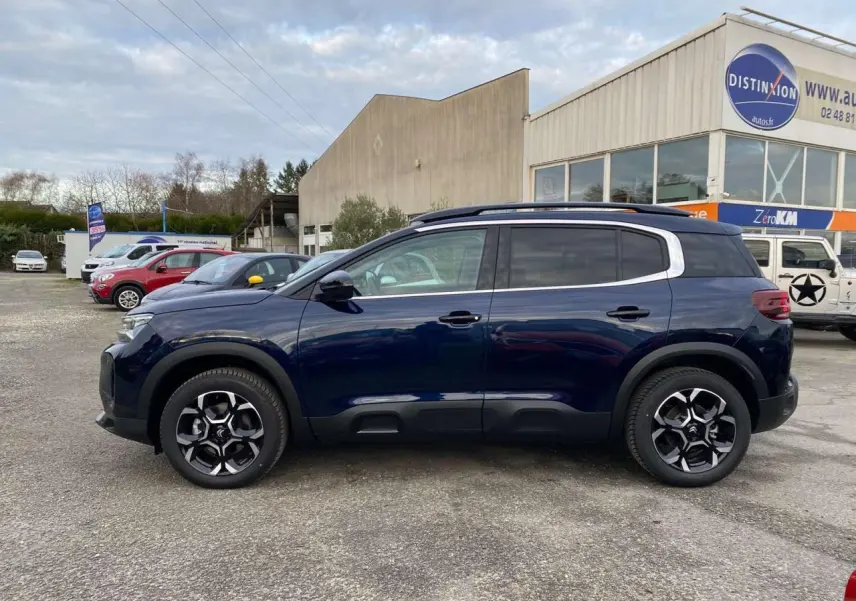 Vue de profil côté gauche d'un Citroën C5 Aircross 2025 bleu éclipse avec jantes noires et toit noir.