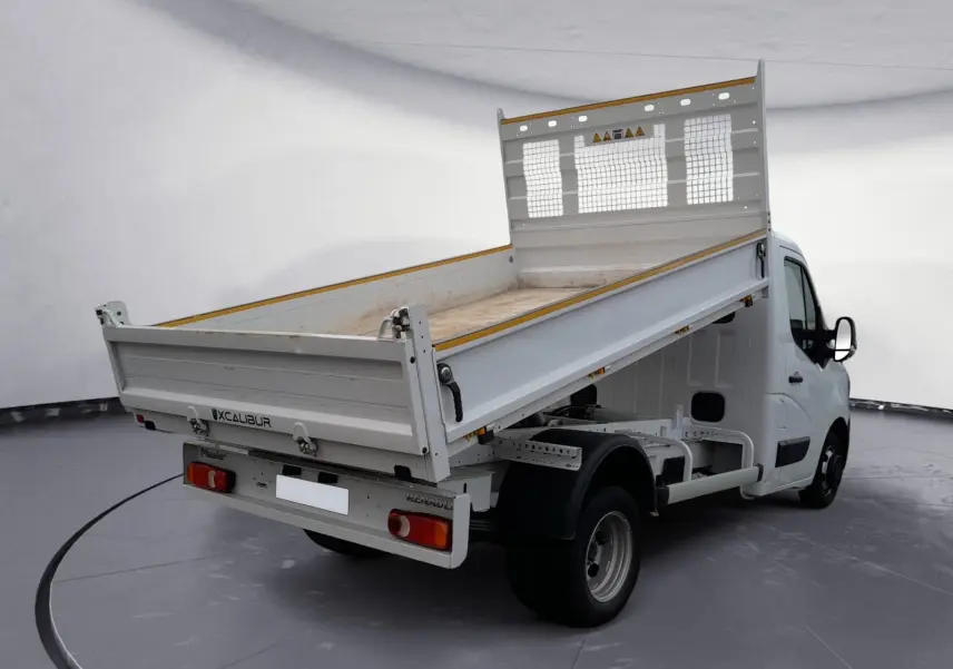 Renault Master blanc vue 3/4 arrière droit avec benne relevée dans un studio lumineux.