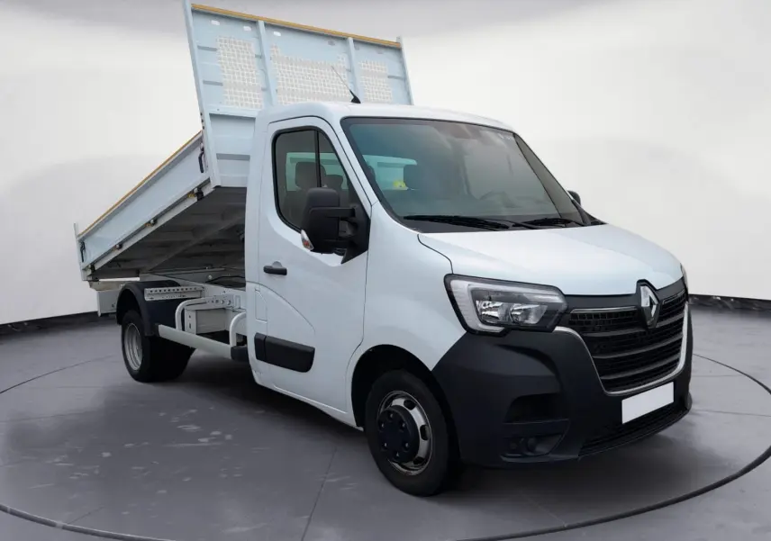 Renault Master blanc vue 3/4 avant droit avec benne relevée, mettant en valeur la cabine et le plateau basculant.