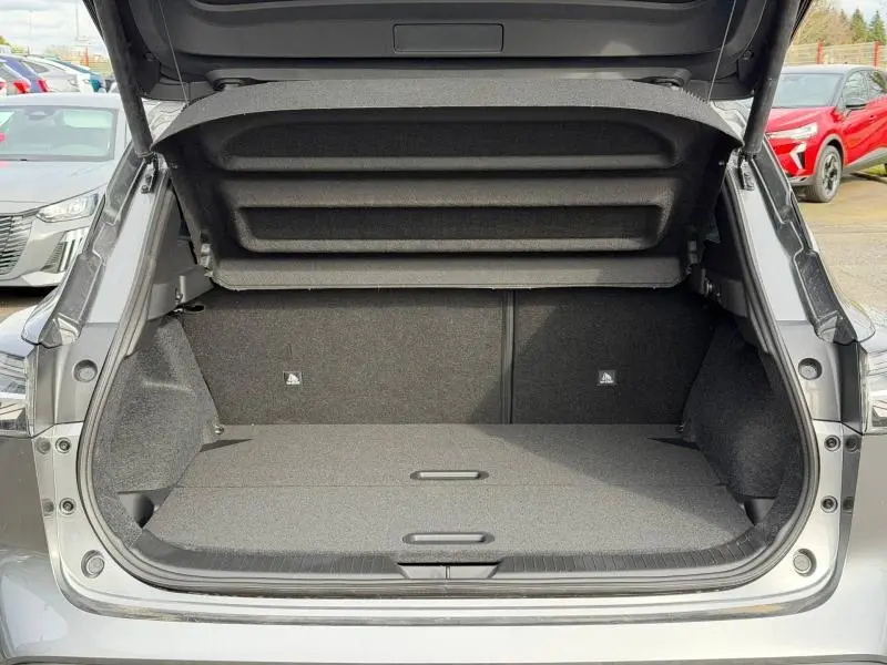 Coffre ouvert vu de l'arrière du Nissan Qashqai Hybrid e-POWER gris Squale métallisé, espace de chargement vide et plancher plat.