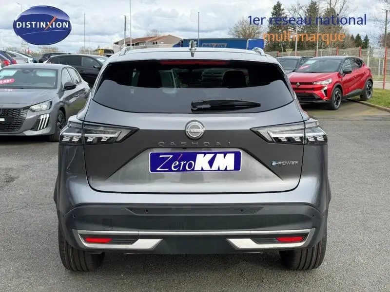 Vue arrière d'un Nissan Qashqai Hybrid e-POWER gris squale métallisé avec feux LED et logo distinctif.