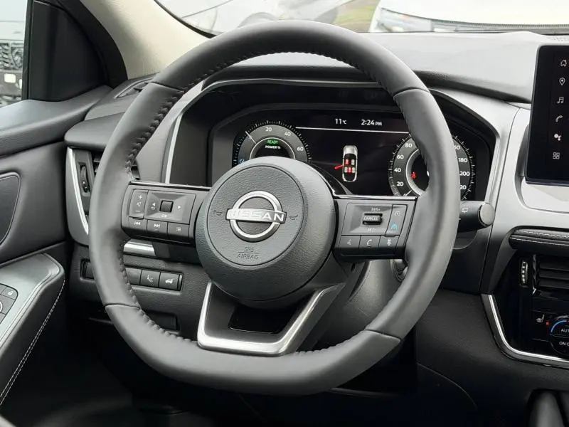 Vue rapprochée du volant cuir multifonction noir du Nissan Qashqai 2025 avec tableau de bord numérique et commandes intégrées.