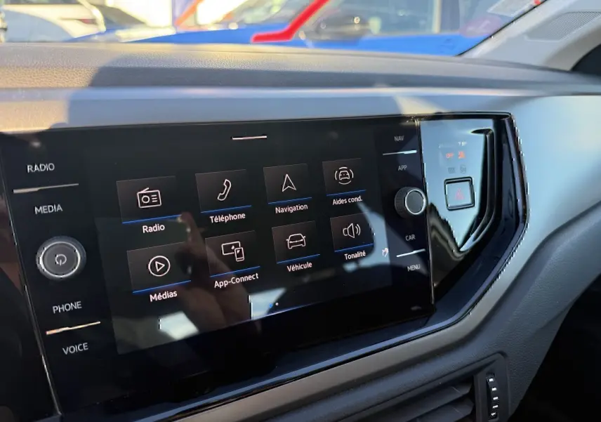 Vue rapprochée de l'écran tactile central noir du tableau de bord de la Volkswagen Polo gris métal 2021.