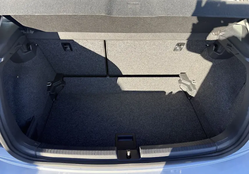 Coffre ouvert vu de l'arrière d'une Volkswagen Polo gris métal 2021, montrant un espace de rangement propre et vide.