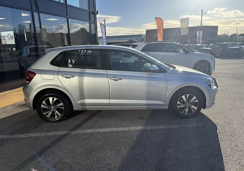 Volkswagen Polo 1.0 TSI 95 Lounge Business gris métal vue de profil côté gauche en extérieur, jantes alliage bicolores.