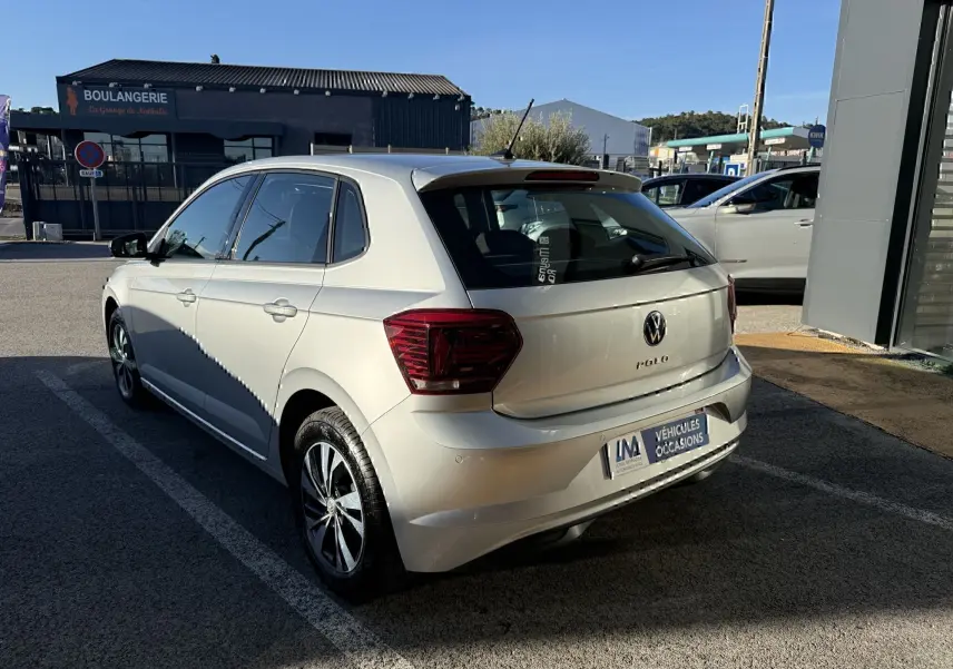 Volkswagen Polo gris métal vue 3/4 arrière droit, avec feux arrière foncés et jantes alliage distinctives.