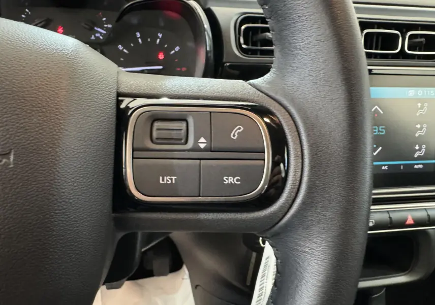 Gros plan sur le volant cuir noir de la Citroën C3 2020, avec commandes audio et téléphone intégrées.