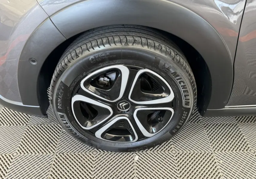 Gros plan sur la roue arrière droite gris foncé d'une Citroën C3 avec jante noire et argentée au design moderne.