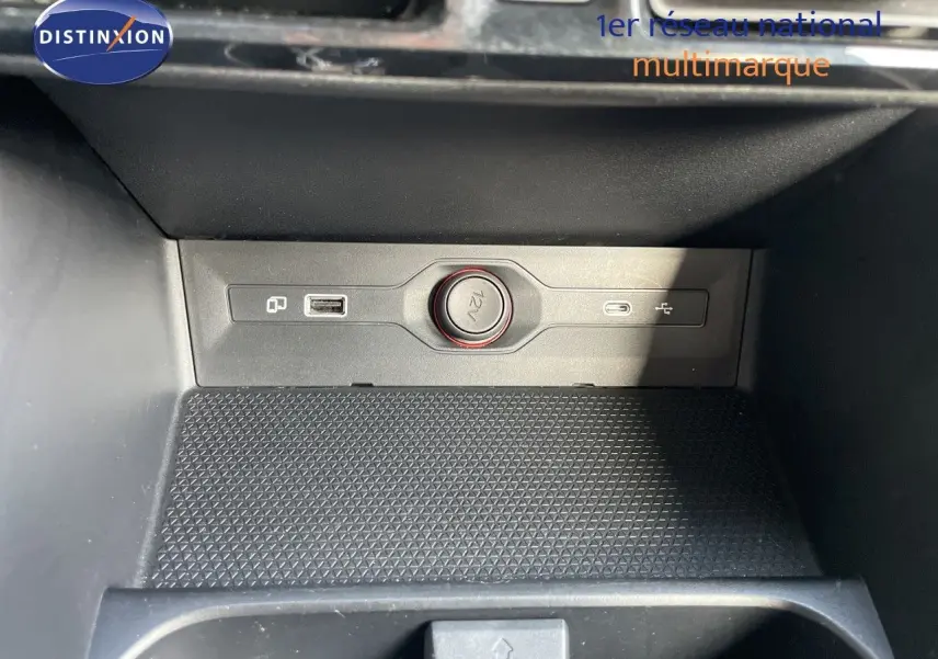Détail de la console centrale du MG3 2025 montrant une prise 12V et deux ports USB dans un intérieur noir.