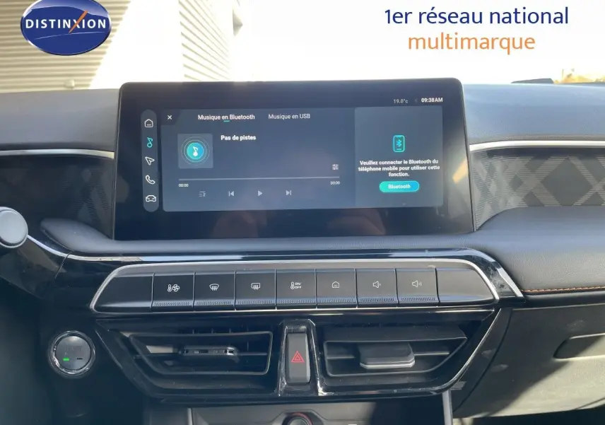 Vue rapprochée du tableau de bord du MG3 2025, écran tactile central affichant la musique Bluetooth, finition noire avec surpiqûres marron.