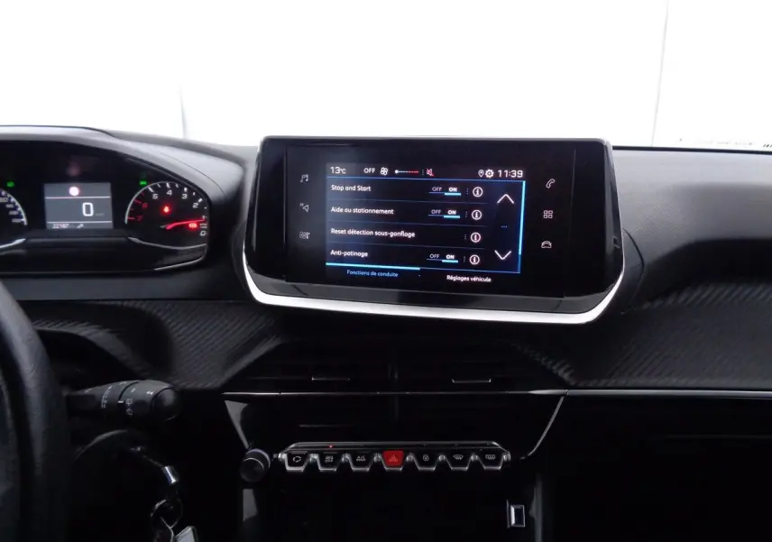 Tableau de bord et écran tactile central de la Peugeot 208 rouge Elixir, vue intérieure frontale détaillée.