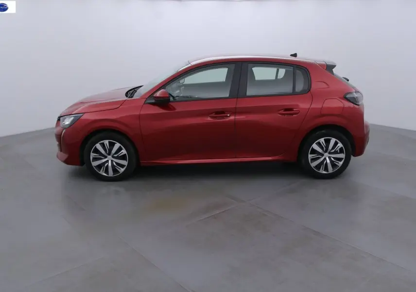 Profil côté gauche d'une Peugeot 208 rouge Elixir Metal avec jantes alliage dans un studio blanc.