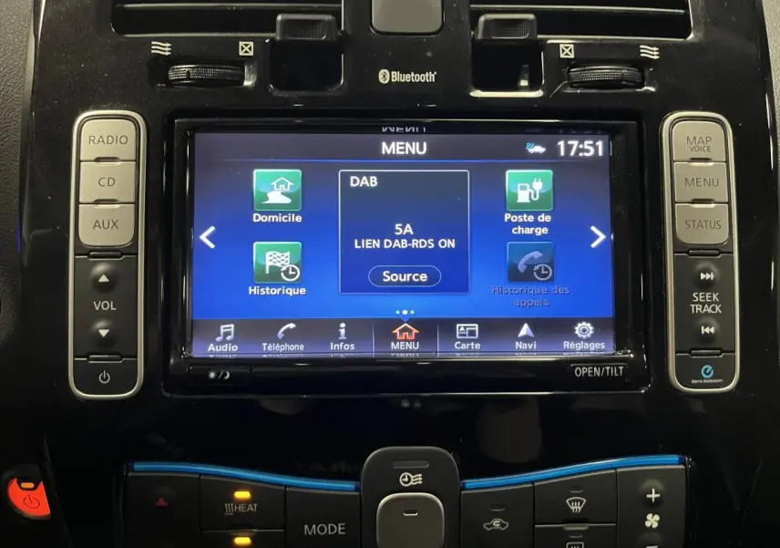 Vue rapprochée de la console centrale du Nissan Leaf rouge 2017, affichant l'écran tactile multimédia et les commandes climatisation.
