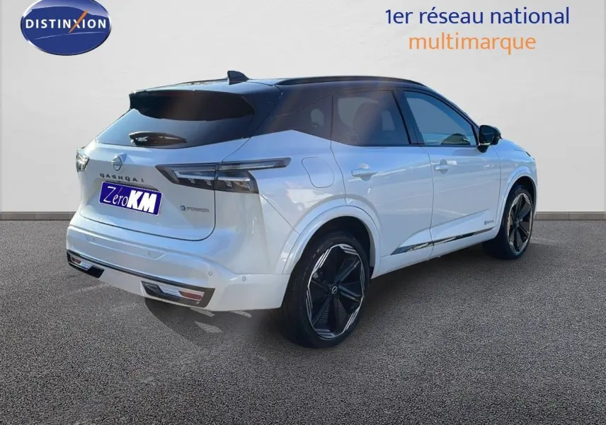 Vue 3/4 arrière droite du Nissan Qashqai blanc nacré à toit noir, soulignant ses feux LED et ses jantes noires distinctives.