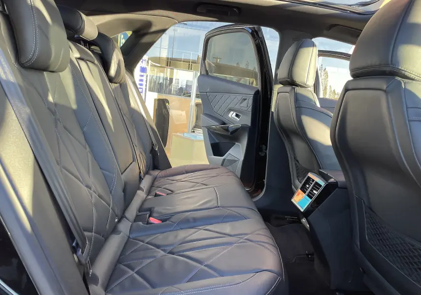 Vue intérieure arrière droite du DS7 2024 noir Perla Nera, sièges cuir noir matelassé et porte arrière ouverte.