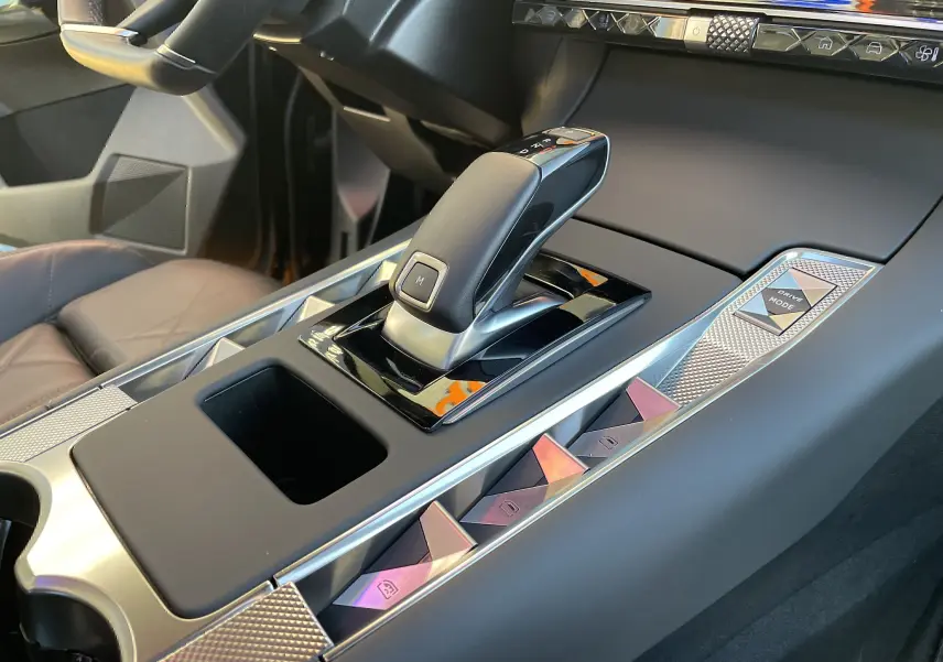 Gros plan sur la console centrale du DS7 2024 noir Perla Nera, mettant en valeur le levier de vitesse automatique et les commandes Drive Mode.