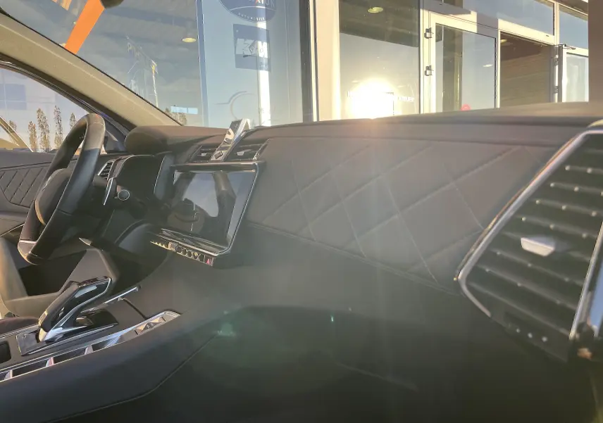 Intérieur côté conducteur du DS7 2024 noir Perla Nera, tableau de bord en cuir noir matelassé avec écran tactile central.