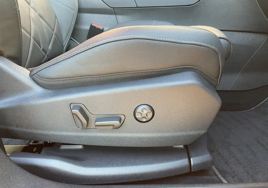 Gros plan sur les commandes de réglage électrique du siège avant en cuir noir du DS7 2024 côté gauche.