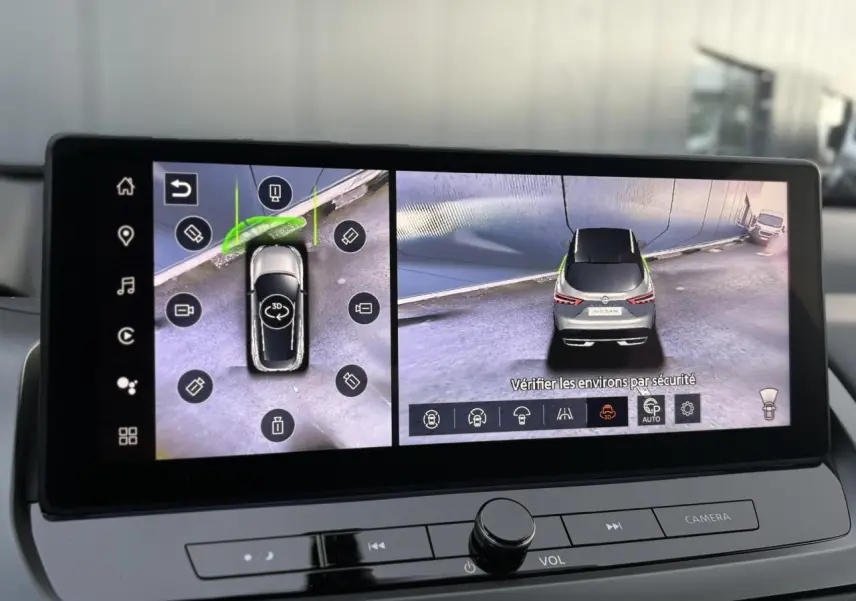 Écran intérieur affichant la vue 360° d'un Nissan Qashqai gris Ceramic en stationnement, vue arrière et dessus.