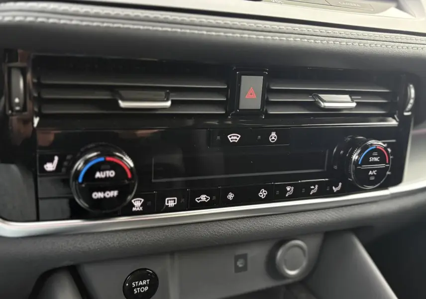 Détail de la console centrale noire du Nissan Qashqai 2025, avec commandes climatisation et bouton Start/Stop.