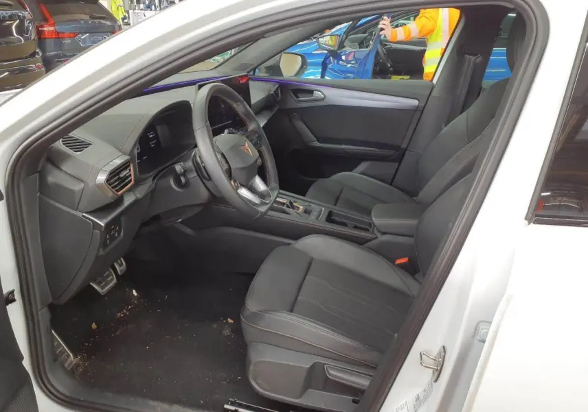 Intérieur de la CUPRA Leon blanc Nevada vu côté conducteur, avec sièges noirs et volant cuir Supersports.