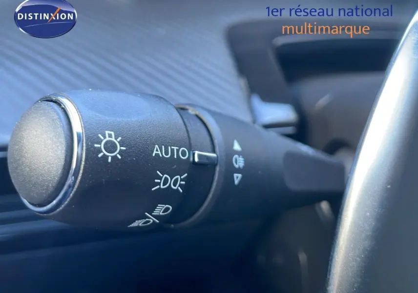 Gros plan sur la commande des phares de la Peugeot 508 SW noire, située à gauche du volant dans l'habitacle.