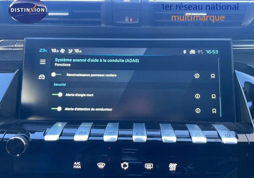 Vue rapprochée de l'écran tactile et des commandes argentées du tableau de bord d'une Peugeot 508 SW noire 2024.