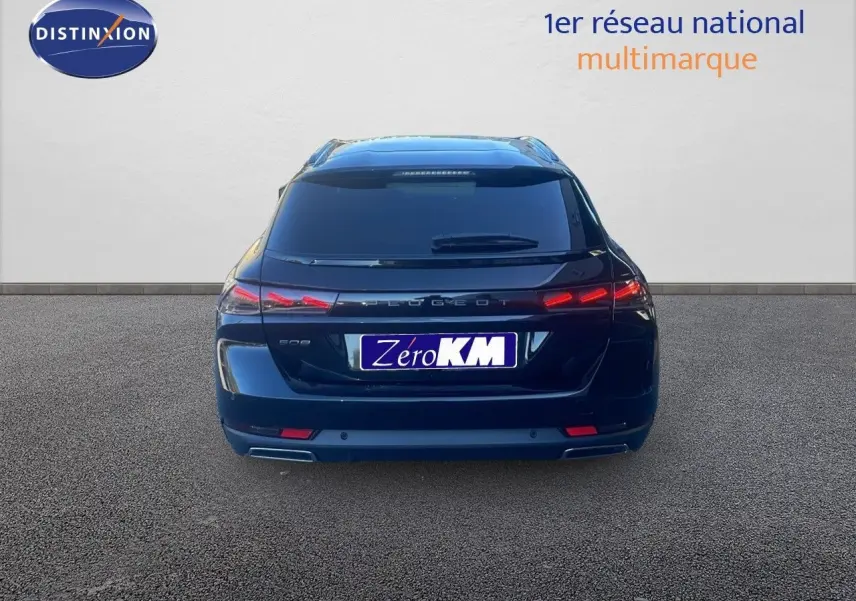 Vue arrière d'une Peugeot 508 SW noire Perla Metal avec feux LED allumés et plaque Zéro KM visible.