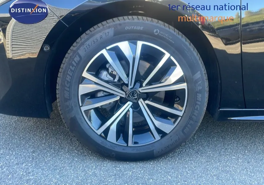 Gros plan sur la roue avant droite de la Peugeot 508 SW noire Perla Metal avec jante alliage bicolore.