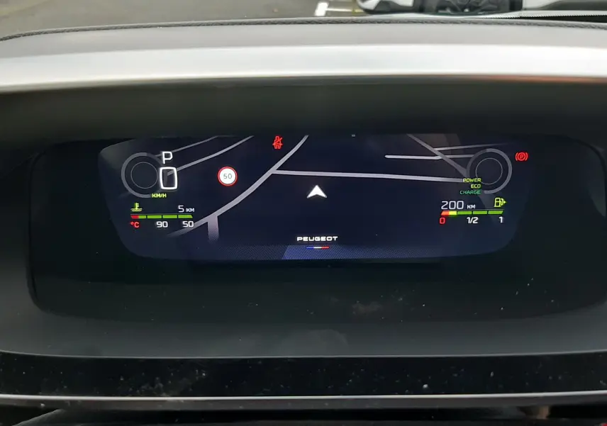 Affichage numérique du tableau de bord de la Peugeot 308 hybride 2025, montrant la navigation et l'état du véhicule.