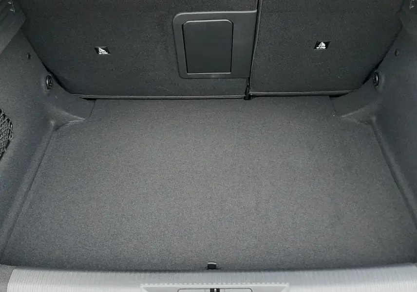 Coffre vide en vue plongeante d'une Peugeot 308 1.2 Hybrid 145ch GT bleu Lagoa, intérieur gris foncé.