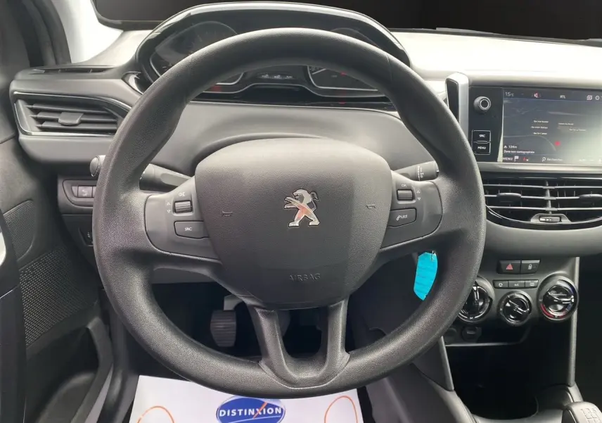 Vue centrée sur le volant noir de la Peugeot 208 AFFAIRE 2019 avec tableau de bord et écran GPS visible.