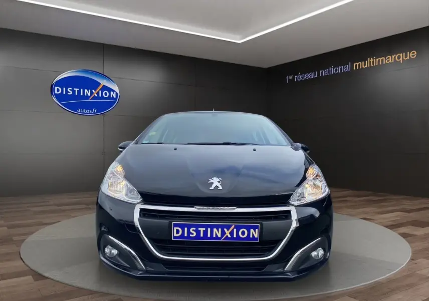 Peugeot 208 Affaire noir vue de face, mettant en valeur sa calandre chromée et ses phares allumés.