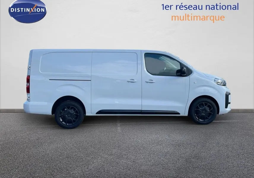 Profil droit d'un Citroën Jumpy Fourgon XL blanc Kaolin avec jantes noires et portes coulissantes arrière visibles.