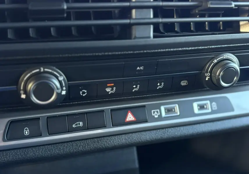 Gros plan sur la console centrale du Citroën Jumpy XL gris Titane, montrant les commandes de climatisation et les boutons de sécurité.