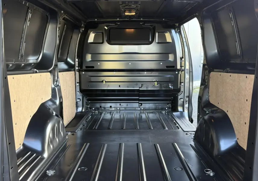 Vue intérieure arrière du Citroën Jumpy XL gris titane, montrant l'espace de chargement avec cloison tôlée et anneaux d'arrimage.