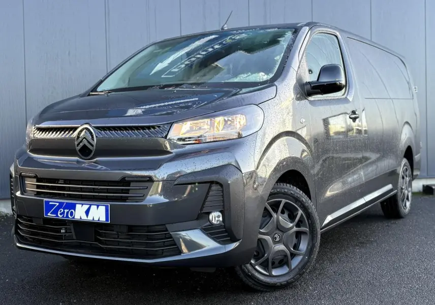 Vue 3/4 avant droite d’un Citroën Jumpy XL gris titane avec pack look et jantes spécifiques, sur sol humide.