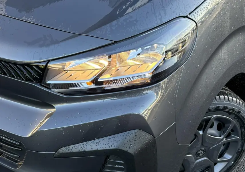 Gros plan sur l'avant droit gris titane du Citroën Jumpy XL 2025 avec phare allumé et jante noire visible