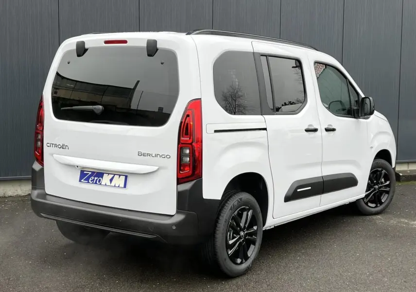 Vue 3/4 arrière droite du Citroën Berlingo blanc Glacier avec jantes alliage noires et lunette arrière ouvrante.