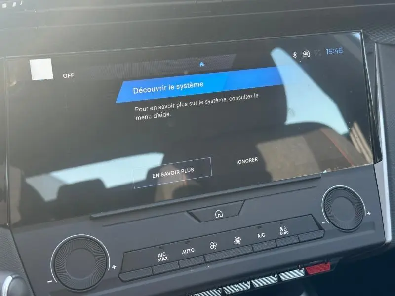 Gros plan sur l'écran tactile central et la console de la Peugeot 308 bleu, mettant en valeur les commandes clim et multimédia.